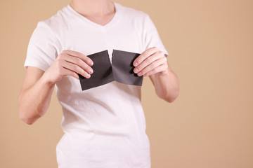 Man tearing a piece of paper in half blank black flyer brochure booklet. Leaflet presentation....