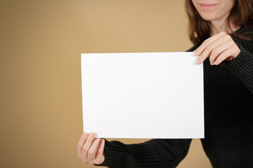 Girl holding white A4 blank paper. Leaflet presentation. Pamphlet hold hands. Woman show clear...