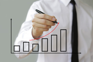 Business man drawing a growth graph and red curve