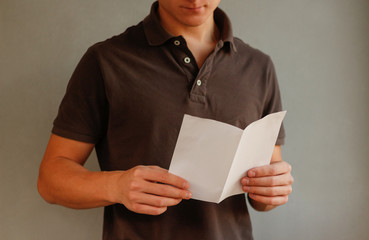 Man reading blank white flyer brochure booklet. Leaflet presentation. Pamphlet hold hands. Man show...
