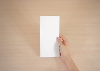 Hands holding blank white brochure booklet in the hand. Leaflet presentation. Pamphlet hand man....