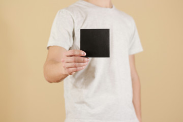 Man showing blank black square flyer brochure booklet. Leaflet presentation. Pamphlet hold hands....