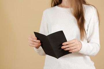 Girl reading blank black flyer brochure booklet. Leaflet presentation. Pamphlet hold hands. Woman...