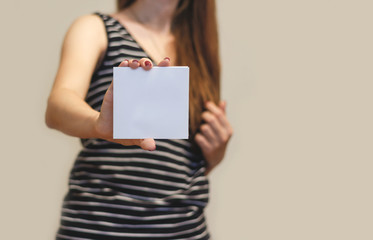 Girl showing blank white square flyer brochure booklet. Leaflet presentation. Pamphlet hold hands....