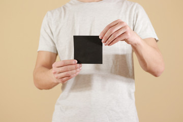 Man showing blank black square flyer brochure booklet. Leaflet presentation. Pamphlet hold hands....