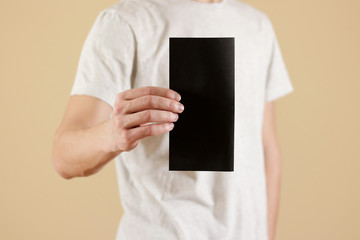Man showing blank black flyer brochure booklet. Leaflet presentation. Pamphlet hold hands. Man show...
