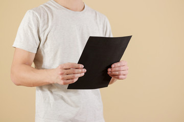 Man holding black A4 paper. Read booklet. Leaflet presentation. Pamphlet hold hands. Man show clear offset paper. Sheet template. Booklet design sheet display read first person