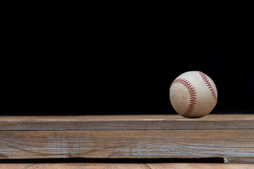 Baseball on a old rustic wooden desk with partial blur background