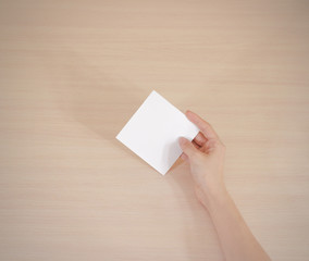 Obraz premium Right hand holding square white paper in the right hand. Leaflet presentation.