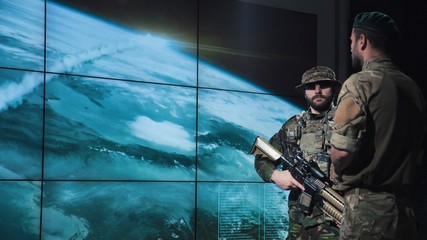 Military men in system control area watching nuclear missile launch looking at digital screen.