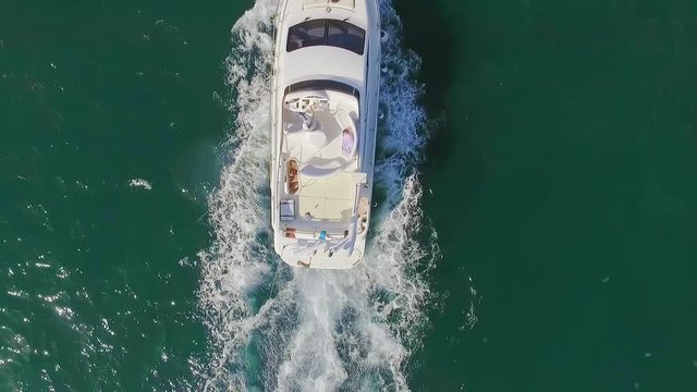 View from copter slowmotion group of young people having fun sailing on luxury yacht over open sea lying on bow enjoying by sunlight