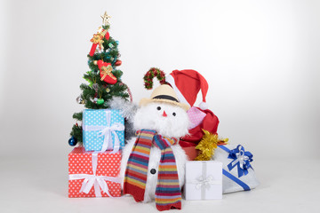 Snowman doll with many gifts boxs and christmas tree on white background