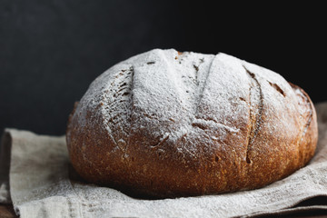 Close-up of fresh rye bread on a black background.