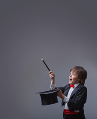 Magician boy performing with magic wand and hard hat