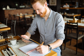 Businessman taking notes in cafe