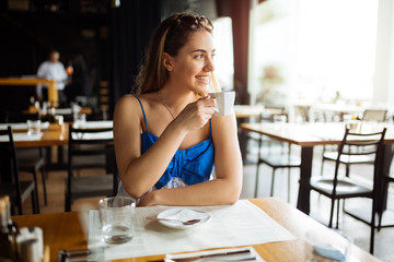 Woman drinking coffee in restaurant