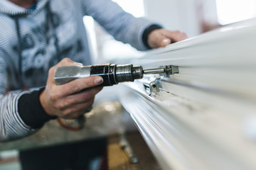 Manual worker assembling PVC doors and windows. Manufacturing jobs. Selective focus. Factory for aluminum and PVC windows and doors production.