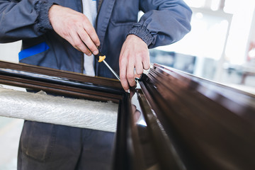 Manual worker assembling PVC doors and windows. Manufacturing jobs. Selective focus. Factory for aluminum and PVC windows and doors production.