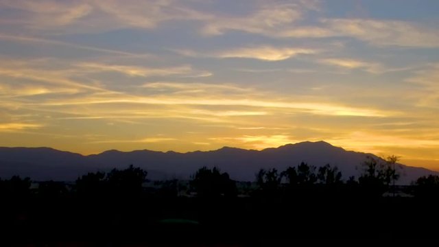 Sunset aerial shot ascending with mountains on the horizon in Palm Desert