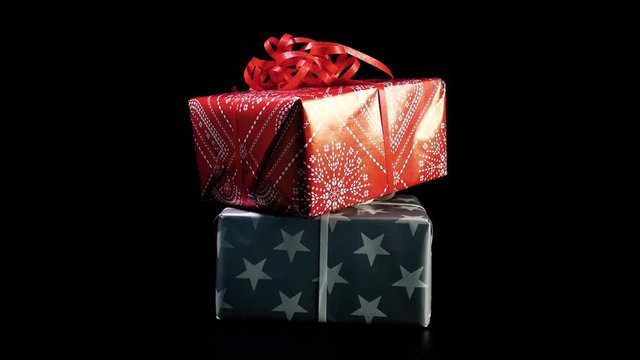 Christmas presents rotate against black background in 4k resolution