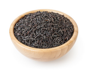 Black tea in wooden bowl isolated on white background with clipping path