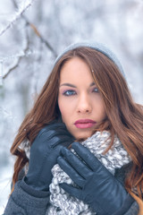 Winter portrait of beautiful young woman in park.