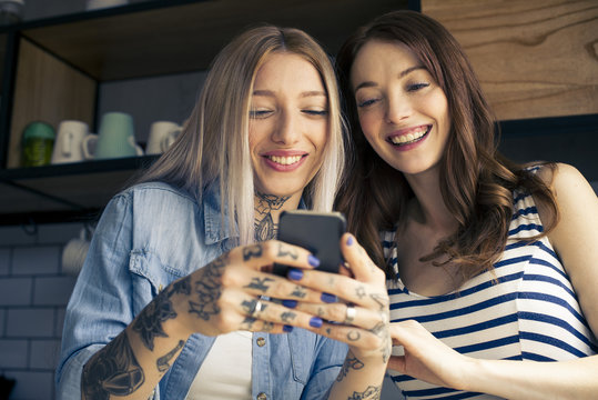 Women looking at smartphone together
