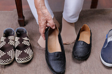 Elderly woman putting on shoes