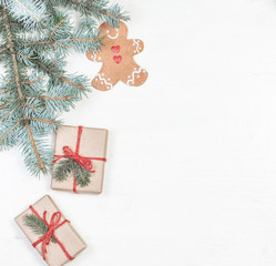 Christmas gifts, fir tree branches, xmas holiday decorations, festive symbols on white wooden background with copyspace. Christmas composition..