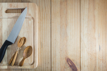 Top view of prepare cooking : knife  and spoon, fork on chopping board on wooden table.