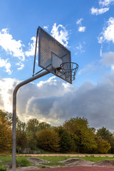 Basketballkorb aus Metall auf einem Basketball Spielfeld, von links