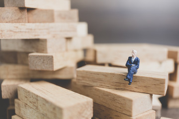 Miniature people : Business People sitting on wood block with wooden background