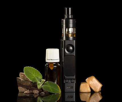 Electronic cigarette, liquid for Smoking and pieces of sweets, isolated on black
