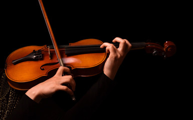 Hands of a woman playing the violin isolated on black