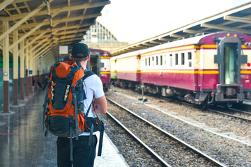 Man with backpack is waiting for a train in Thailand