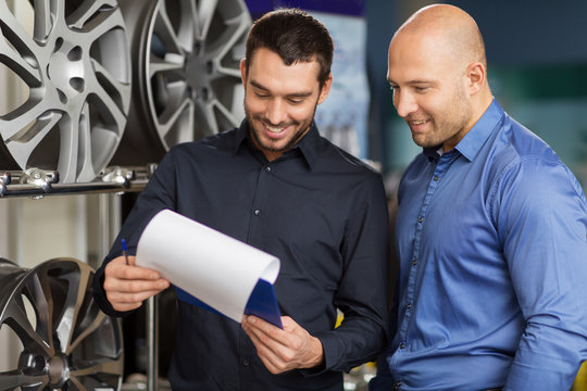 customer and salesman at car service or auto store