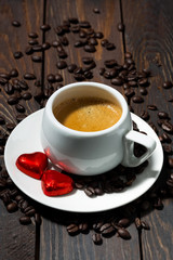 cup of espresso and chocolate sweets in the form of a heart, vertical, top view