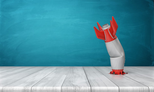 3d rendering of a red and silver realistic model of a retro rocket stands crashed into a wooden desk on a blue background.