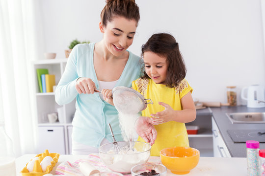 happy mother and daughter baking at home