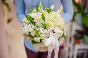 Florist holding a beautiful white wedding bouquet of flowers