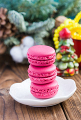 Pink macaroons with christmas decorations on woooden background