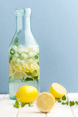 Bottle with cold refreshing lemonade on a blue background..