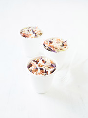 Portions of low-caloric vegetable coleslaw salad in a paper cups.