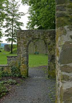 Gemauerter Bogen in einem Park als Teil einer Burgruine