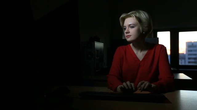 Student girl working on the computer, window sunset until late at night in the classroom or campus library dolly shot