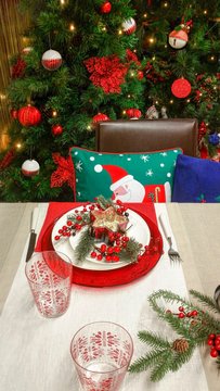 Beautiful table setting with Christmas decoration in red and beige colors