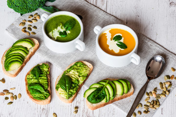 Vegetarian healthy food. Soup and vegan sandwiches. Different sandwiches with avocado. Brunch on white wooden background