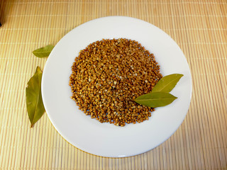buckwheat in a white plate on a light background