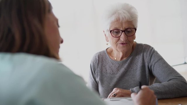 Nurse giving prescription to elderly woman