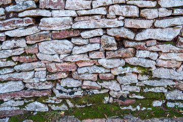 Wall of old natural stone. The texture of the stone.